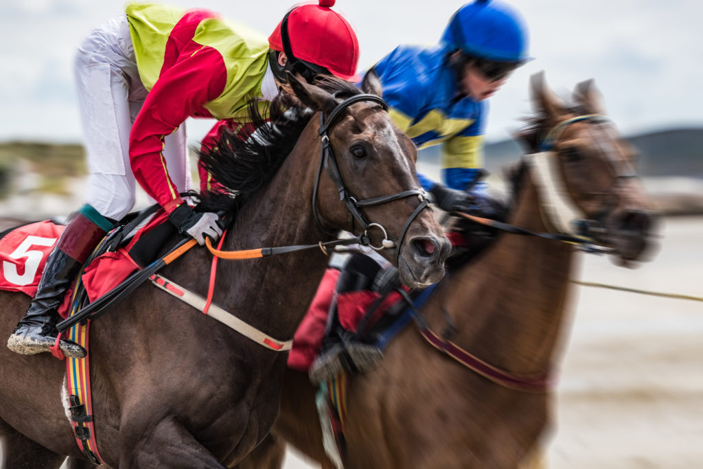 Close-up on jockey and race horse galloping at speed, motion blur zoom effect